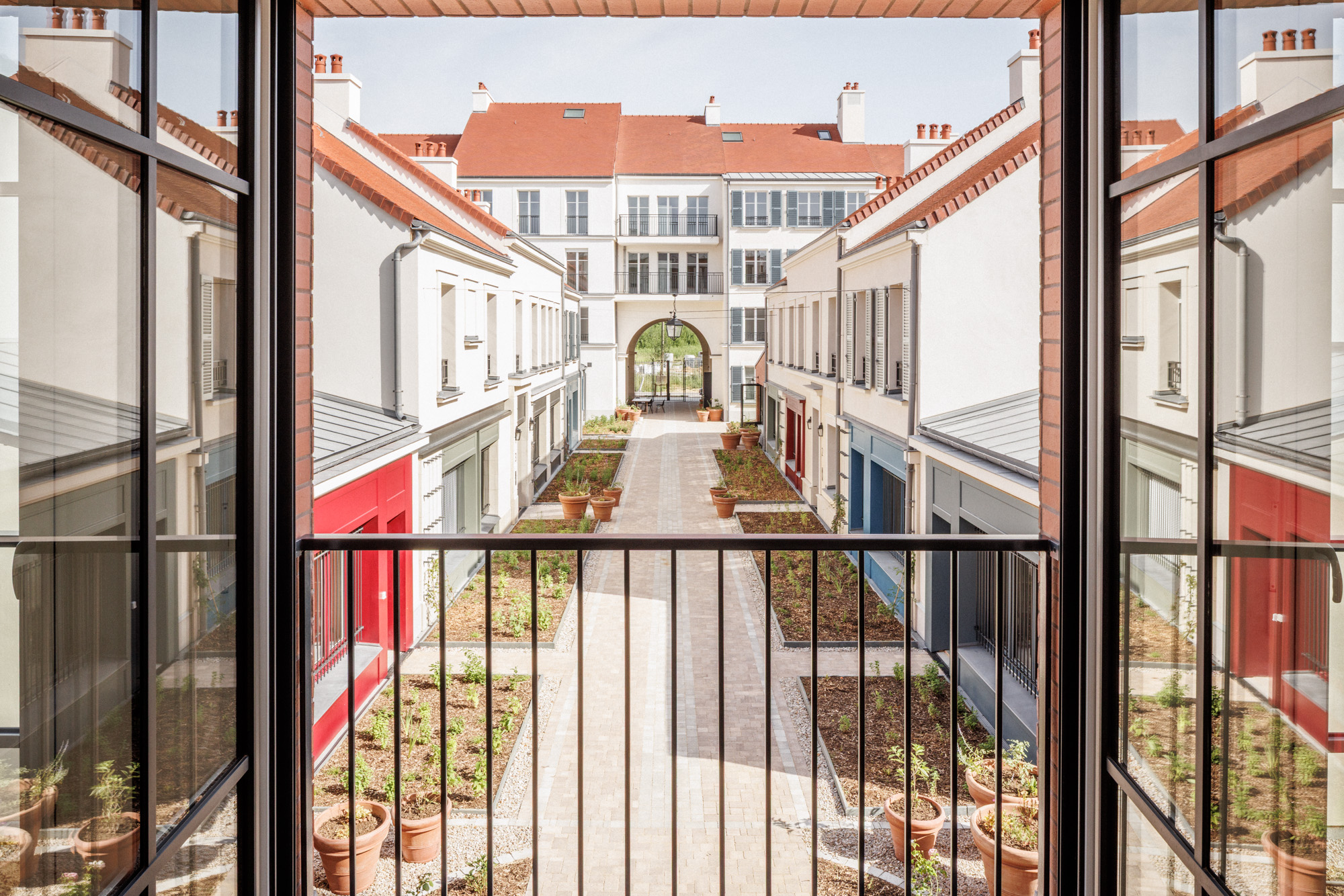 Vue depuis le bâtiment « La Fabrique » sur la Cour des Artisans, venelle paysagère desservant un ensemble de 47 logements sociaux à Serris (Seine-et-Marne), conçu par Cussac Architectes.